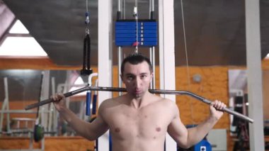 Spor salonunda vücut geliştiren bir adam, bir barla çalışıyor, trisepsleri geliştiriyor, büyük göğüs kası ve ön deltoid kası var. Aşk sporlarından anlayan, spor salonuna giden, sağlıklı beslenen...