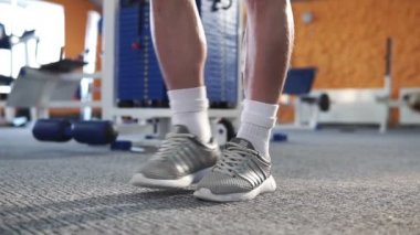 Spor salonunda egzersiz yapan genç bir erkek..