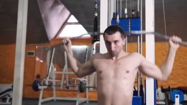 Spor salonunda vücut geliştirme uzmanı, bir barla çalışıyor, trisepsleri geliştirmek, büyük göğüs kası ve ön deltoid kası geliştirmek için..