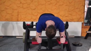 Spor salonunda vücut geliştirme uzmanı, bir barla çalışıyor, trisepsleri geliştirmek, büyük göğüs kası ve ön deltoid kası geliştirmek için..