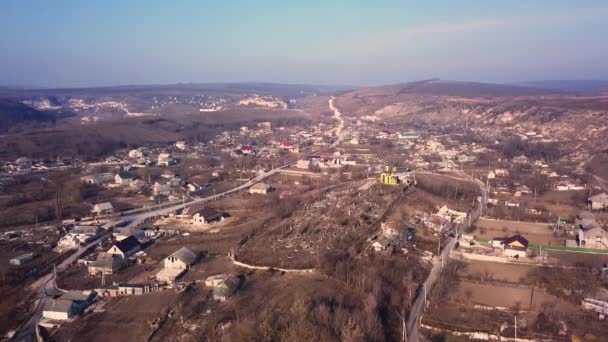 Flight over the small village with small church in center. Sunny spring day. — Stock Video