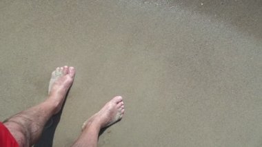 Erkek bacakları. Denizde erkek ayağı. Deniz kıyısında erkek ayakları.
