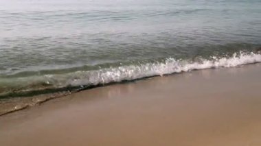 Kumsal, köpüklü okyanus, kumları yıkayan deniz dalgaları. Dalgalar kumsala vuruyor. Dalgaların sesi