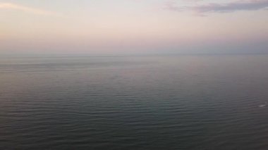 Gündoğumu gökyüzü arkaplanının hava görüntüsü. Denizin üzerinde sabah gökyüzü bulutları olan havadan dramatik altın bir gün doğumu. Güneşin doğuşunda çarpıcı gökyüzü bulutları. Hava görüntüsü. 4k.
