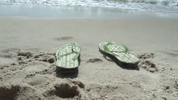 Мужские тапочки на пляже смыло водой — стоковое видео
