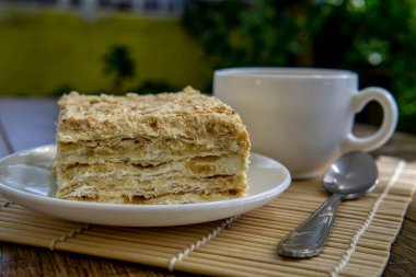 Kahverengi masa arkasında kek olan bir fincan çay.