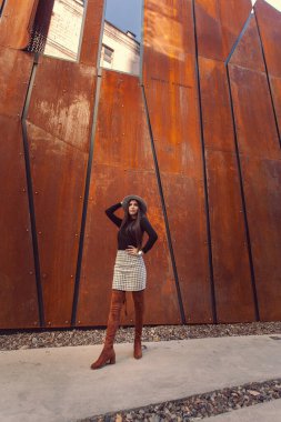 Modern binanın arka planında poz veren güzel bir kız modeli.