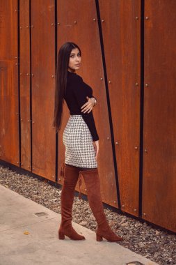 Modern binanın arka planında poz veren güzel bir kız modeli.