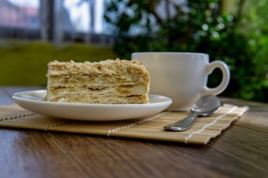 Kahverengi masa arkasında kek olan bir fincan çay.