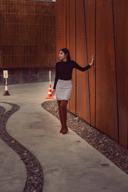 Modern binanın arka planında poz veren güzel bir kız modeli.