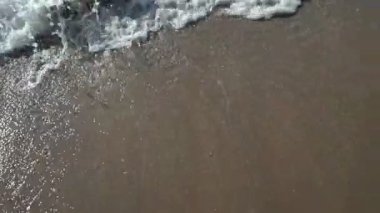 Kumsal, köpüklü okyanus, kumları yıkayan deniz dalgaları. Dalgalar kumsala vuruyor. Dalgaların sesi