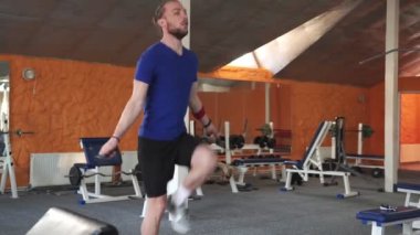 Atletik Üstsüz Adam, Issız Fabrika Sıkı Spor Salonu 'nda Sıçrama İpi ile Egzersiz Yapıyor. Yoğun Çapraz Vücut Eğitiminden dolayı ter içinde kalmış..
