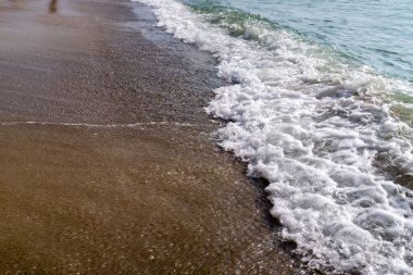 Kumlu sahilde denizin yumuşak dalgası