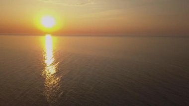 Gündoğumu gökyüzü arkaplanının hava görüntüsü. Denizin üzerinde sabah gökyüzü bulutları olan havadan dramatik altın bir gün doğumu. Güneşin doğuşunda çarpıcı gökyüzü bulutları. Hava görüntüsü. 4k.