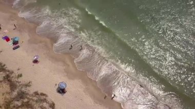 Plaj ve deniz havası manzarası. Denizde yumuşak dalgalar ve çakıl taşları. Suyun rengi sabahları çok güzel parlıyor. 4k video