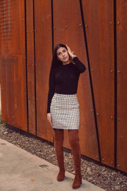 Modern binanın arka planında poz veren güzel bir kız modeli.