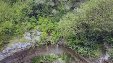 Yeşil ormanda smalll şelale üzerinde uçuş. Drone 4k 30fps ile çekildi