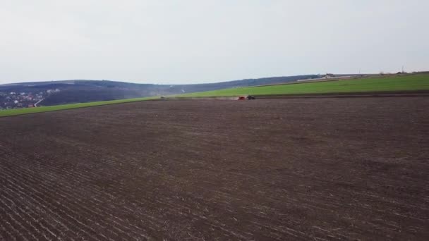 Vue aérienne du tracteur avec semoir monté effectuant l'ensemencement direct des cultures sur un champ agricole labouré. Technique d'ensemencement des cultures sur le terrain. Semis est le processus de plantation de graines dans le sol .