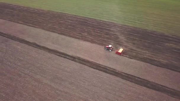 밭에서 농작물을 묘사되어 트랙터의 농작물을 재배하는 기술이다 뿌리는 은씨를 뿌리는 — 비디오