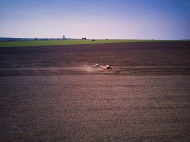 Bir tarlada traktör bahar ekimi yapıyor, İHA pov 'un üst görüntüsü.