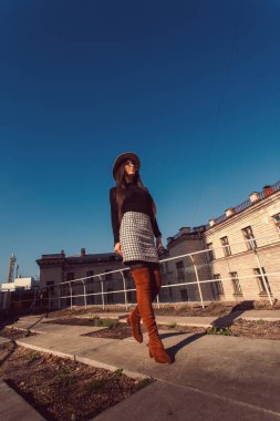 Genç, güzel, şık bir kız sokakta yürüyor. Şapkalı kız cadde boyunca yürüyor..