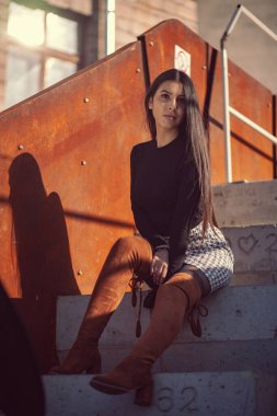 Binanın basamaklarında oturan şık kız modeli.