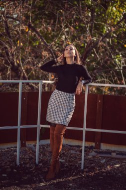 Şehir parkında poz veren genç ve modaya uygun bir kızın moda kadın portresi..