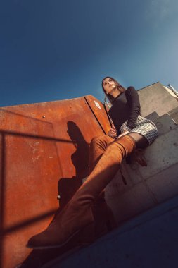 Binanın basamaklarında oturan şık kız modeli.