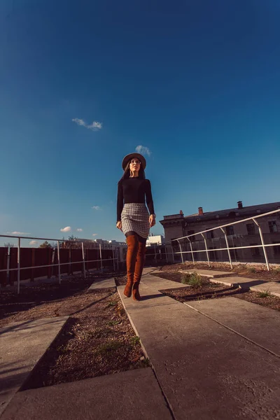 Genç, güzel, şık bir kız sokakta yürüyor. Şapkalı kız cadde boyunca yürüyor..