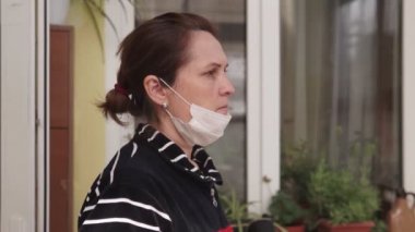 Portre esmer kadın Coronavirus COVID-19 virüsünü karantinaya alırken yüzüne sıkıca tıbbi maske takıyor. Salgın, zatürree, hijyen. Salgın. Yakın plan.