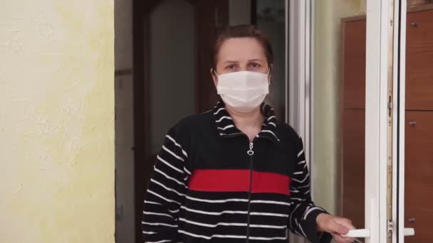 Kvinna Medicinsk Mask Går Huset Och Stänger Dörren Efter Sig — Stockvideo