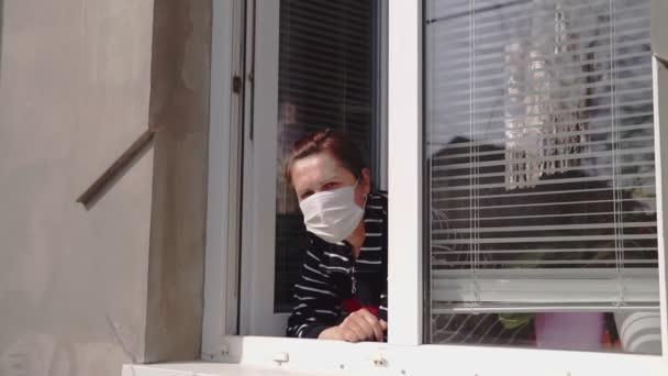 Een Vrouw Met Een Medisch Masker Haar Gezicht Kijkt Uit — Stockvideo