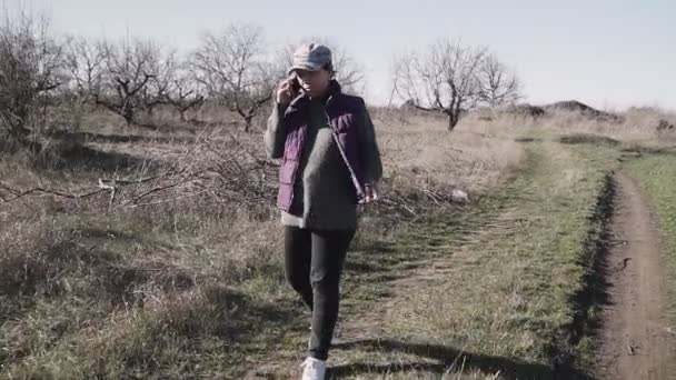 Una Joven Está Caminando Por Camino Rural Hablando Por Teléfono — Vídeos de Stock