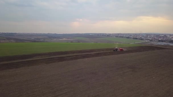 Vue aérienne du tracteur avec semoir monté effectuant l'ensemencement direct des cultures sur un champ agricole labouré. Technique d'ensemencement des cultures sur le terrain. Semis est le processus de plantation de graines dans le sol .