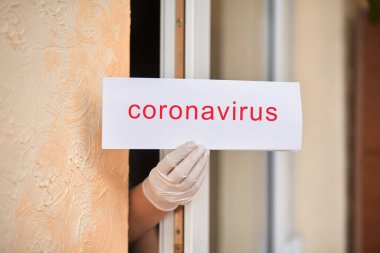 Coronavirus harfli tıbbi maskeli bir kadın. Covid 19.
