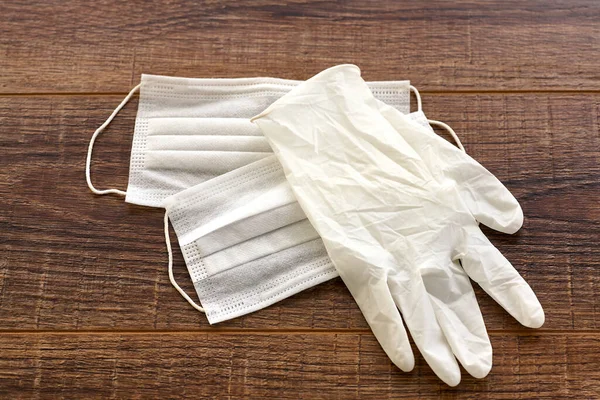 Medical face mask and gloves on wood table with copy space on the right side. Concept of well preparation before going out for protecting the coronavirus and other germs. — Stock Photo, Image
