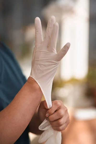 Female surgeon or nurse wearing a sterile suit putting on sterile rubber gloves to perform a surgery, Hand wearing a surgical gloves before starting the operation, Step by step procedures. — Stock Photo, Image