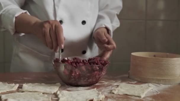 El proceso de hacer un pastel. La mujer pone el relleno en la masa y la dobla en un rollo . — Vídeos de Stock