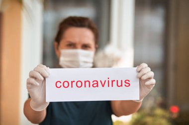 Coronavirus harfli tıbbi maskeli bir kadın. Covid 19.