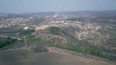 İnsansız hava aracı Avrupa 'nın tepeleri ve ormanlarıyla çevrili küçük bir köyünde uçuyor. Baharın başında. Moldova Cumhuriyeti.