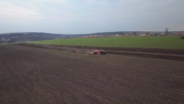 Vue aérienne du tracteur avec semoir monté effectuant l'ensemencement direct des cultures sur un champ agricole labouré. Technique d'ensemencement des cultures sur le terrain. Semis est le processus de plantation de graines dans le sol .