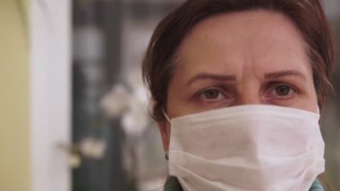 Yüzünde koruyucu bir tıbbi maske takmış beyaz bir esmerin yakın portresi. Grip virüsü ve koronavirüs salgını her yerde. Covid 19.