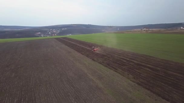 耕作された農業分野で作物の直接播種を行うマウントされた種子を持つトラクターの空中ビュー 畑で作物を播種するための技術 播種は地面に種を植えるプロセスです — ストック動画