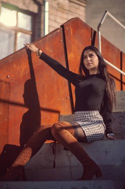Binanın basamaklarında oturan şık kız modeli.