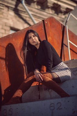 Binanın basamaklarında oturan şık kız modeli.