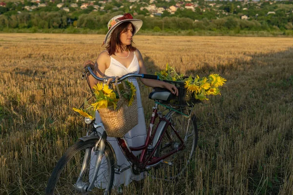 Женщина Шляпе Белом Платье Велосипедом Гуляет Пыльце Подсолнухами — стоковое фото