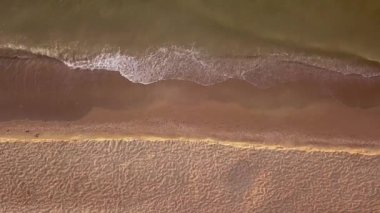 Plaj ve deniz havası manzarası. Denizde yumuşak dalgalar ve çakıl taşları. Suyun rengi sabahları çok güzel parlıyor. 4k video