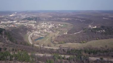 İnsansız hava aracı Avrupa 'nın tepeleri ve ormanlarıyla çevrili küçük bir köyünde uçuyor. Baharın başında. Moldova Cumhuriyeti.
