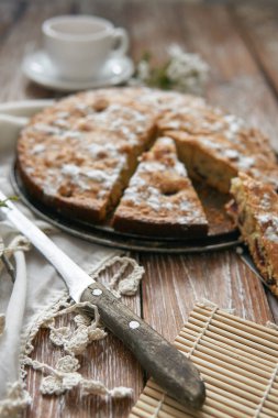 Vişneli ev yapımı turta ve koyu renkli ahşap tahta arka planda beyaz çay. Kırsal tarzda yemek.