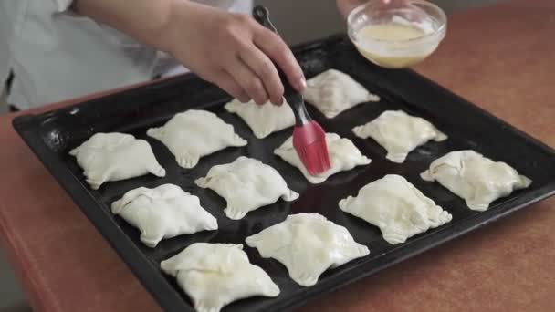 Smear the pies with egg yolk, homemade baking — Stock Video